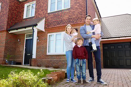 Family standing in front of new home