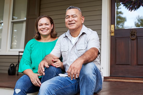 Happy couple sitting on front porch