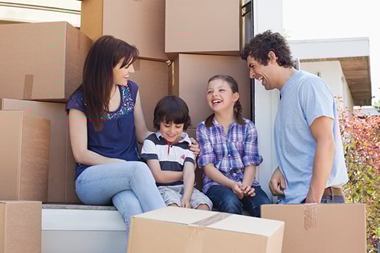 Family sitting in back of moving van