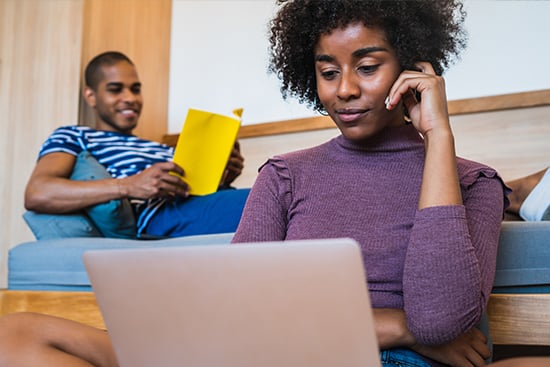 Couple doing research on refinancing in their living room